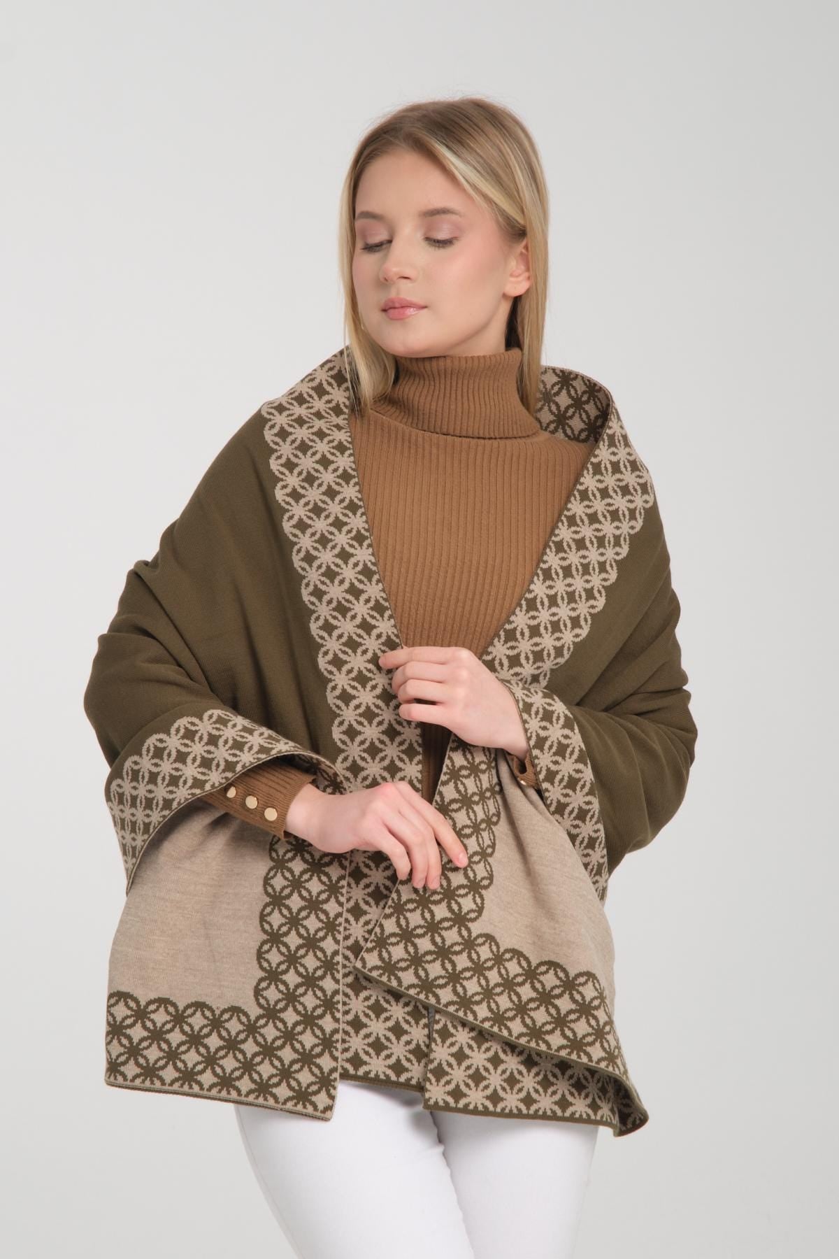 Könnte beinhalten: Ein olivgrüner Schal mit geometrischem Muster am Rand. Der Schal ist über einem braunen Rollkragenpullover drapiert. Der Rand weist ein sich wiederholendes kreisförmiges Design in einem helleren Beigeton auf. Der Schal ist aus einem weichen, fließenden Stoff gefertigt.